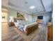 Spacious bedroom featuring wooden furniture, tray ceilings, an adjacent bathroom, and neutral colored walls at 14521 Tanja King Blvd, Orlando, FL 32828