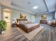 Cozy bedroom with wooden accents, tray ceilings, neutral walls, and an adjacent bathroom at 14521 Tanja King Blvd, Orlando, FL 32828