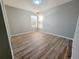 Bright, empty bedroom with wood-look flooring and plenty of natural light at 14521 Tanja King Blvd, Orlando, FL 32828