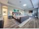 Modern bedroom with tray ceiling, adjacent bath, sleek furniture, and stylish wood flooring at 14521 Tanja King Blvd, Orlando, FL 32828