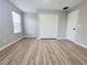 Spacious bedroom with wood-look flooring, white closet doors, and a bright window at 14521 Tanja King Blvd, Orlando, FL 32828