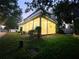 Home exterior at twilight with covered porch and lush green lawn at 14521 Tanja King Blvd, Orlando, FL 32828