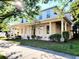 Two-story home with a charming front porch supported by columns and surrounded by mature landscaping at 14521 Tanja King Blvd, Orlando, FL 32828