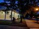 Home exterior at dusk featuring a sidewalk and manicured lawn with mature trees at 14521 Tanja King Blvd, Orlando, FL 32828