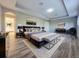 Staged main bedroom featuring a large bed, bench, light gray walls, and modern decor at 14521 Tanja King Blvd, Orlando, FL 32828