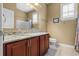 Bathroom featuring vanity with granite countertop, a large mirror, and wood cabinets at 14738 Porter Rd, Winter Garden, FL 34787