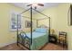 Bedroom features canopy bed, plantation shutters, ceiling fan, and bedside table creating cozy and inviting space at 14738 Porter Rd, Winter Garden, FL 34787