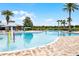 Large community pool with a splash zone, seating areas, and mature palm trees at 14738 Porter Rd, Winter Garden, FL 34787