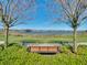 Scenic view of a bench overlooking a serene lake in a well-maintained community at 14738 Porter Rd, Winter Garden, FL 34787