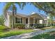 Inviting one-story home featuring a covered porch, lush landscaping, and a well-maintained lawn at 14738 Porter Rd, Winter Garden, FL 34787