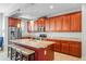 Kitchen island with granite countertops and modern appliances, seating, and rich wood cabinetry at 14738 Porter Rd, Winter Garden, FL 34787