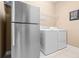 Clean and functional laundry area with stainless steel refrigerator, washer and dryer at 14738 Porter Rd, Winter Garden, FL 34787