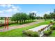 Community park featuring a playground, benches, and walking trails amidst lush landscaping at 14738 Porter Rd, Winter Garden, FL 34787