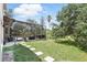 Lush backyard featuring a screened-in patio, stepping stones, and mature landscaping at 158 Hickory Stick Ct, Debary, FL 32713