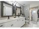 Well-lit bathroom featuring double sinks, modern fixtures, and a shower with patterned tiling at 158 Hickory Stick Ct, Debary, FL 32713