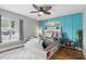 Stylized bedroom featuring a ceiling fan, stylish accent wall and natural light from the window at 158 Hickory Stick Ct, Debary, FL 32713
