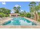 Beautiful community pool area with lounge chairs, umbrellas, and a charming pool house at 158 Hickory Stick Ct, Debary, FL 32713