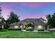 Stunning home with a well-manicured lawn, elegant architectural details, and lush landscaping, creating a welcoming curb appeal at 158 Hickory Stick Ct, Debary, FL 32713