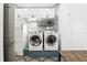 Functional laundry room with modern washer and dryer, white cabinets, and stylish decor at 158 Hickory Stick Ct, Debary, FL 32713