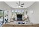 Bright and airy living room with a large sectional couch, arched windows, and a view of the pool area at 158 Hickory Stick Ct, Debary, FL 32713