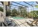 Swimming pool with patio seating, tropical plants, and screened enclosure at 158 Hickory Stick Ct, Debary, FL 32713