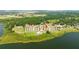 Aerial view of lakeside condo complex, showcasing its pool, manicured grounds, and serene lakeside setting with an arrow pointing to unit at 16300 County Road 455 # 606, Montverde, FL 34756