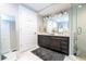 Bathroom showcasing double sinks with dark wood cabinetry, tub and shower at 16300 County Road 455 # 606, Montverde, FL 34756
