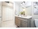 Bright bathroom with a gray vanity and modern lighting, complementing the white tile floors and spacious closet at 16300 County Road 455 # 606, Montverde, FL 34756