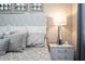 Close-up of bedroom with cushioned headboard, designer nightstand lamp, and plush pillows at 16300 County Road 455 # 606, Montverde, FL 34756