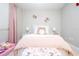 Cozy bedroom featuring a bed with a decorative headboard, soft pink bedding, and plush pillows, creating a relaxing atmosphere at 16300 County Road 455 # 606, Montverde, FL 34756