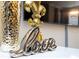 Close up of interior decor featuring a 'love' sign, golden fleur de lis and gold vase on a white surface at 16300 County Road 455 # 606, Montverde, FL 34756