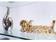 Close-up showcasing elegant silver and gold decorative pieces displayed on a clear glass shelf, adding sophistication at 16300 County Road 455 # 606, Montverde, FL 34756