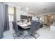 Open-concept dining room with modern table setting and partial view of the kitchen and living room at 16300 County Road 455 # 606, Montverde, FL 34756