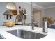 Modern kitchen featuring stainless steel faucet, quartz countertops and unique round mirror decor at 16300 County Road 455 # 606, Montverde, FL 34756