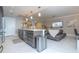 Open-concept living area boasts a kitchen island, pendant lighting, and a cozy seating area with a TV for modern living at 16300 County Road 455 # 606, Montverde, FL 34756