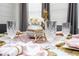 Close up of a lavish table setting with crystal glasses, gold cutlery and pink napkins at 16300 County Road 455 # 606, Montverde, FL 34756