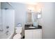 Cozy bathroom features framed mirror, dark counters, shower and updated fixtures at 201 Glenn St, Leesburg, FL 34748