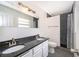 Well-lit bathroom with double sink vanity, framed mirror, and a walk-in shower at 201 Glenn St, Leesburg, FL 34748