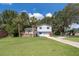 Charming split level home with a well-maintained lawn, mature trees and a welcoming front porch at 201 Glenn St, Leesburg, FL 34748
