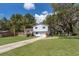 Charming split level home with a well-maintained lawn, mature trees and a welcoming front porch at 201 Glenn St, Leesburg, FL 34748