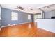 Sunlit living room with hardwood floors, neutral paint and a seamless transition to the dining area at 201 Glenn St, Leesburg, FL 34748
