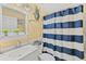 Bathroom with striped curtain, white fixtures, vanity with decor, and nautical themed decorations at 20321 Majestic St, Orlando, FL 32833