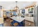 Bright kitchen with white cabinetry, a blue island, an open layout, and stainless steel appliances at 20321 Majestic St, Orlando, FL 32833