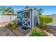 The charming shed features a blue exterior, decorative accents, and well-maintained landscaping at 20321 Majestic St, Orlando, FL 32833