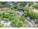 Aerial view of a home with a dark roof, surrounded by lush greenery and mature trees at 204 Green Lake Cir, Longwood, FL 32779