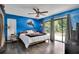 Stylish bedroom with dolphin mural, ceiling fan, hardwood floors, and sliding glass doors to the backyard at 204 Green Lake Cir, Longwood, FL 32779