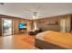 Large bedroom with hardwood floors, access to lanai, a TV, and a comfy leather recliner at 204 Green Lake Cir, Longwood, FL 32779