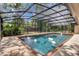 Enclosed pool with brick trim, screen, and a view of the surrounding greenery at 204 Green Lake Cir, Longwood, FL 32779