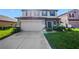 Inviting two-story home with a well-maintained lawn and a two-car garage at 2120 Lilipetal Ct, Sanford, FL 32771