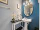 Stylish half bathroom with pedestal sink, decorative accents, and blue accent wall at 2120 Lilipetal Ct, Sanford, FL 32771